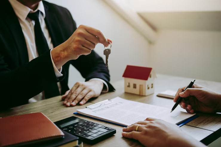 Homem entregando uma chave de uma casa para outra pessoa, representando a busca por um financiamento para dívida condominial.