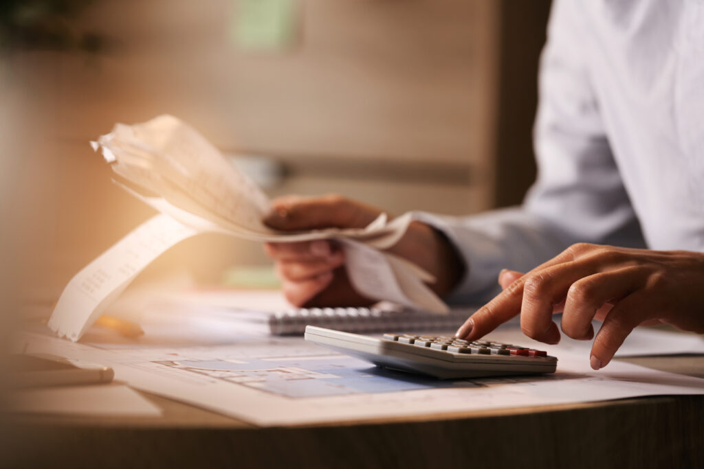 Homem utilizando a calculadora para calcular as taxas e dívidas condominiais, representando a busca de uma solução judicial para evitar as cobranças.