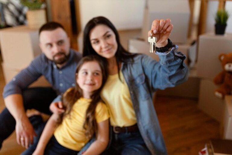 Casal e filha segurando as chaves de um apartamento, representando a importância de evitar a inadimplência condominial.